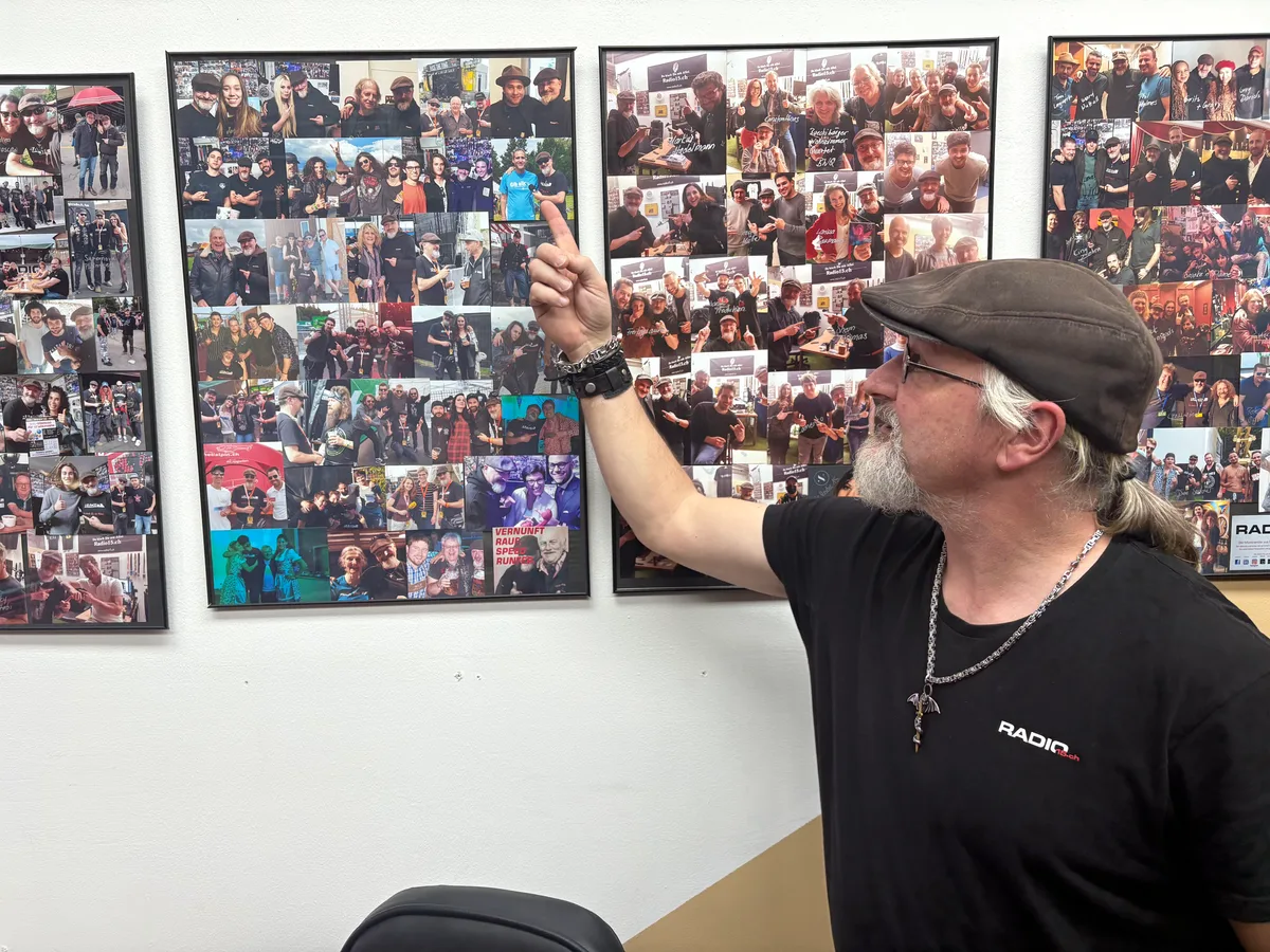 Viele grosse Namen waren bei Mathias Betschart schon zu Besuch – Bilder von diesen Personen hängen im Studio. Betschart zeigt auf ein Bild, welches ihn mit einem früheren Interviewpartner zeigt.